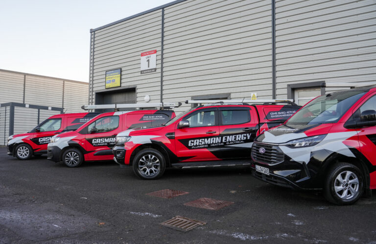A fleet of four branded GasMan Energy vehicles parked outside the head office in Hillington, Glasgow.