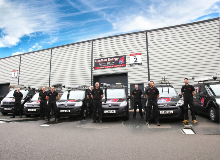 The staff of GasMan Energy posing with the old black vans outside the office in Hillington.